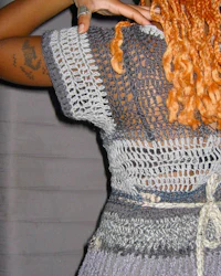 a woman wearing a crocheted dress with orange hair